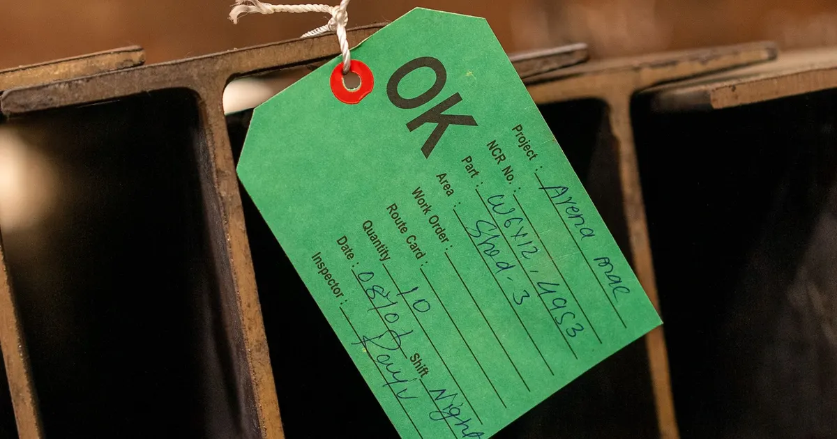Green OK inspection tag with project, quantity and inspector fields hanging on steel sections, an example of during production inspection records